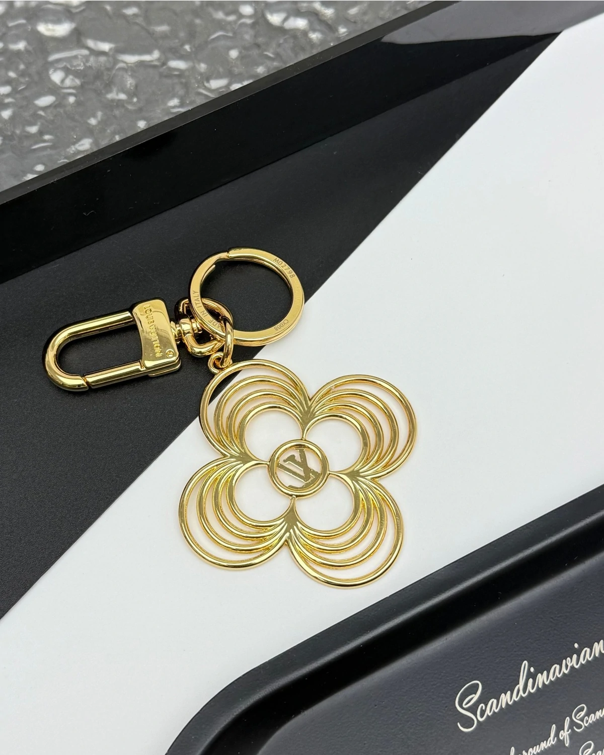 With its precious feminine style and floral shape, the LV Breeze key holder adds a bright touch of sophistication to a handbag or set of keys. Its delicate design features slim strands of gold-colored metal depicting a round-petaled Monogram Flower. An LV Circle signature in the center makes this handy