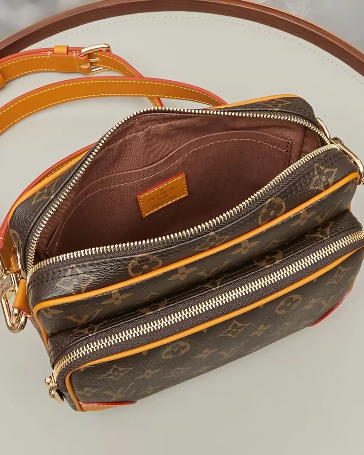 nil-monogram-archive (6) Part of the Monogram Archive collection, the Nil is an on-trend small bag made from Monogram coated canvas with natural cowhide-leather trim. Blending vintage details with modern elegance, it features reenforced corners and the pearl zip-pulls recently introduced by Pharrell Williams. A removable handle and a detachable strap give carry options.